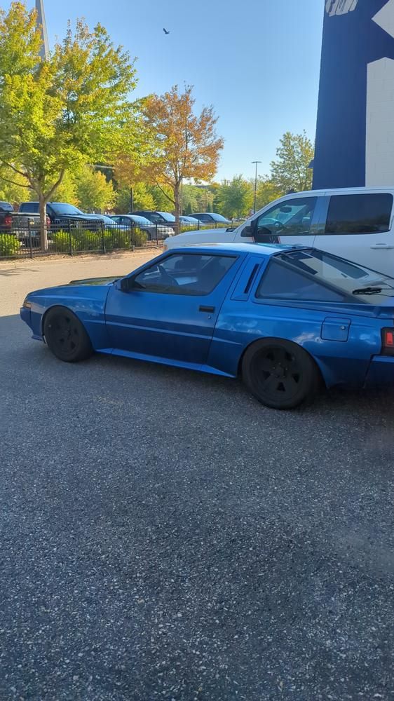 Blue 1988 Chrysler Conquest (Mitsubishi Starion) parked in a lot, seen from the side