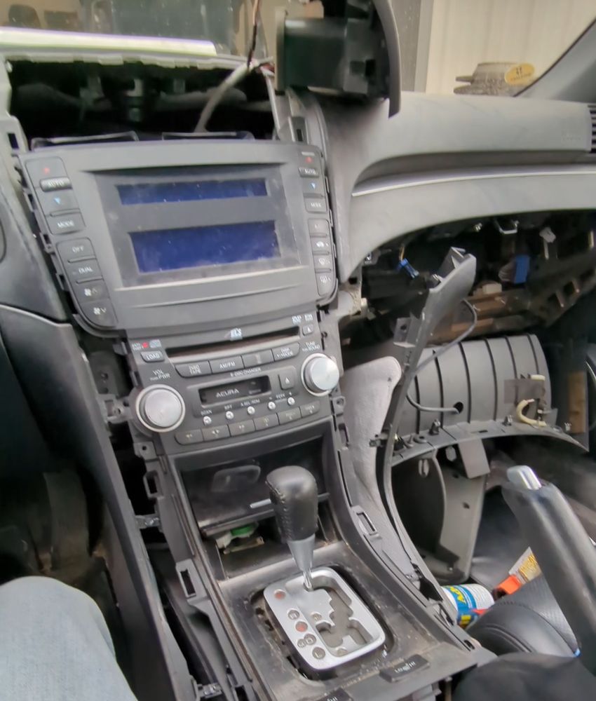 Center console and factory radio of a 2006 Acura TL with the dash trim removed